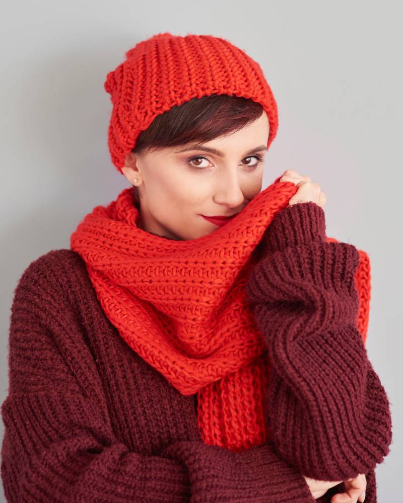 Close-up of a woman in red and maroon knitwear, showcasing a warm winter style