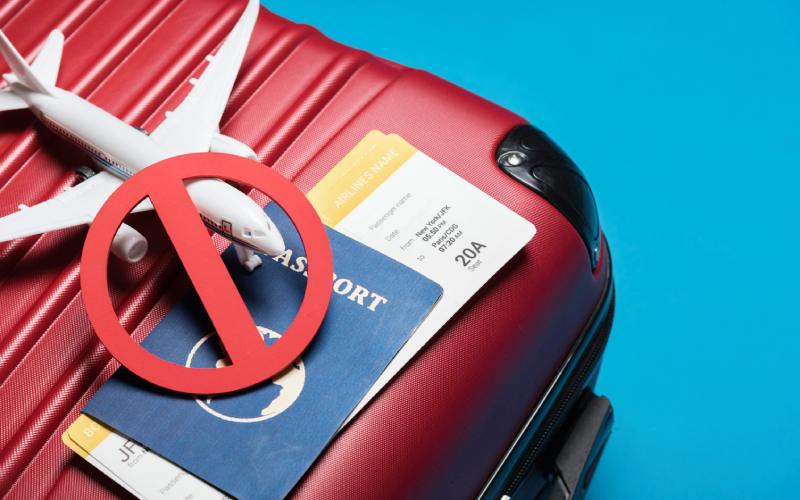 Luggage, airplane model, ticket & passport with blue background